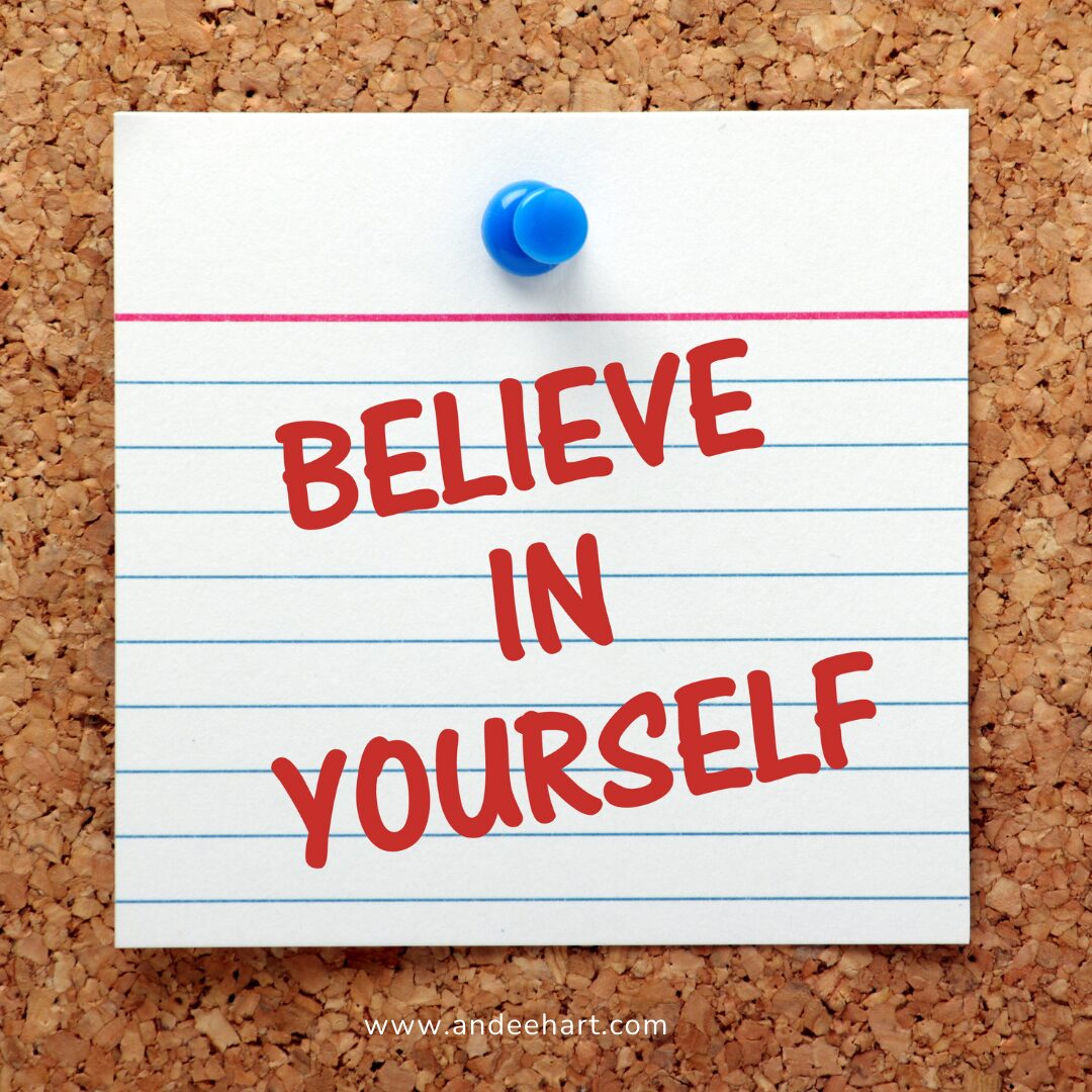 Image is a post it note on a cork board and it says Believe in Yourself