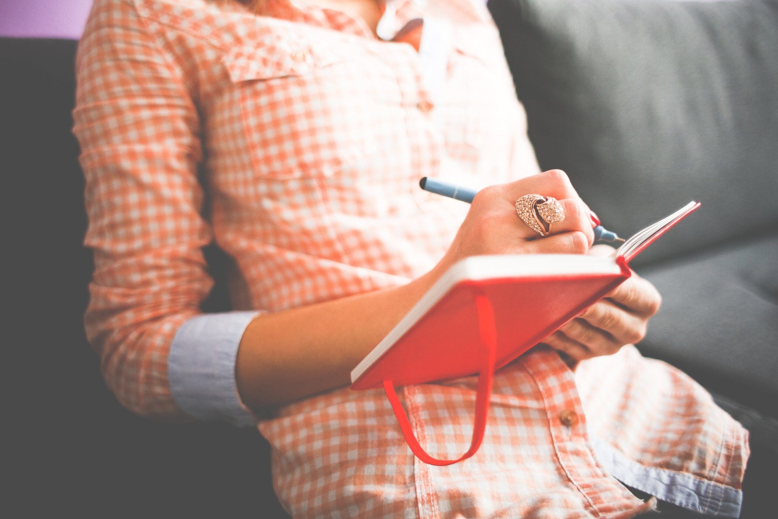 Woman Journaling in a Red Notebook