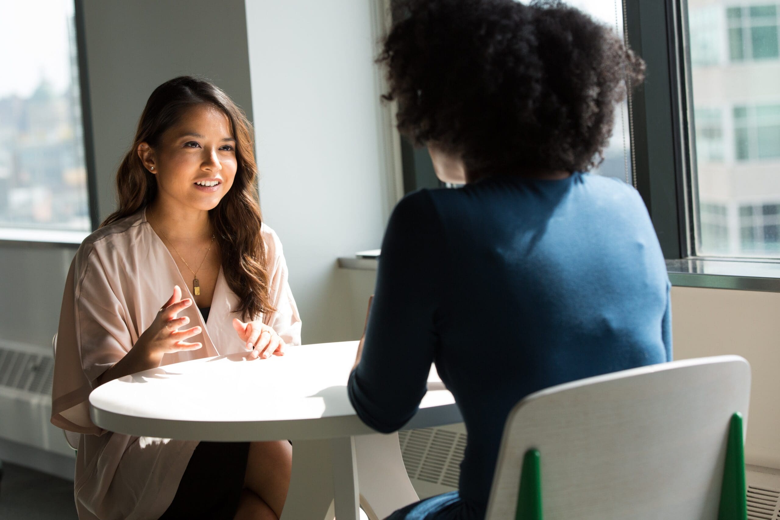 Two business women at a table talking